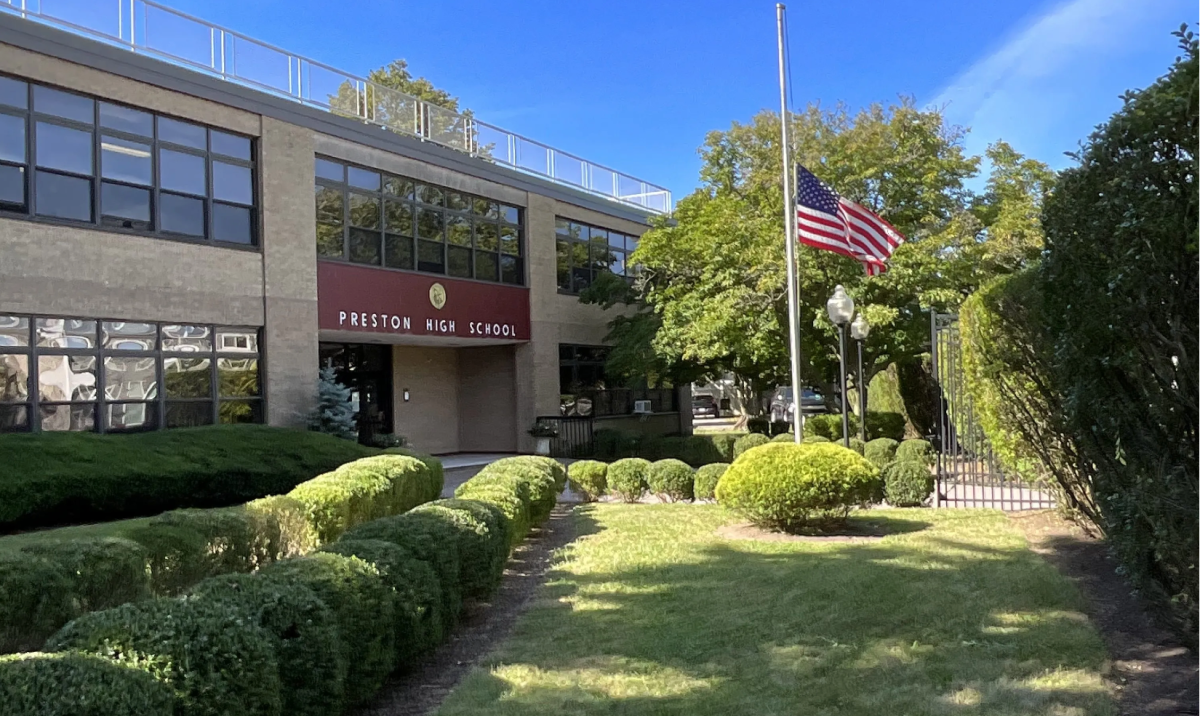 Preston High School entrance in the Bronx with American flag at half-mast, saved by Bally’s $8.5 million deal to prevent closure